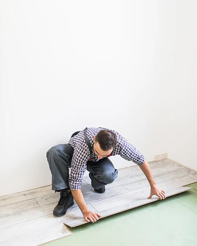 worker processing floor with laminated flooring boards